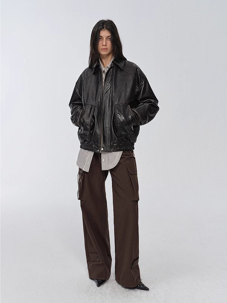 "New York Student" black leather bomber jacket styled with brown cargo pants — full-length view