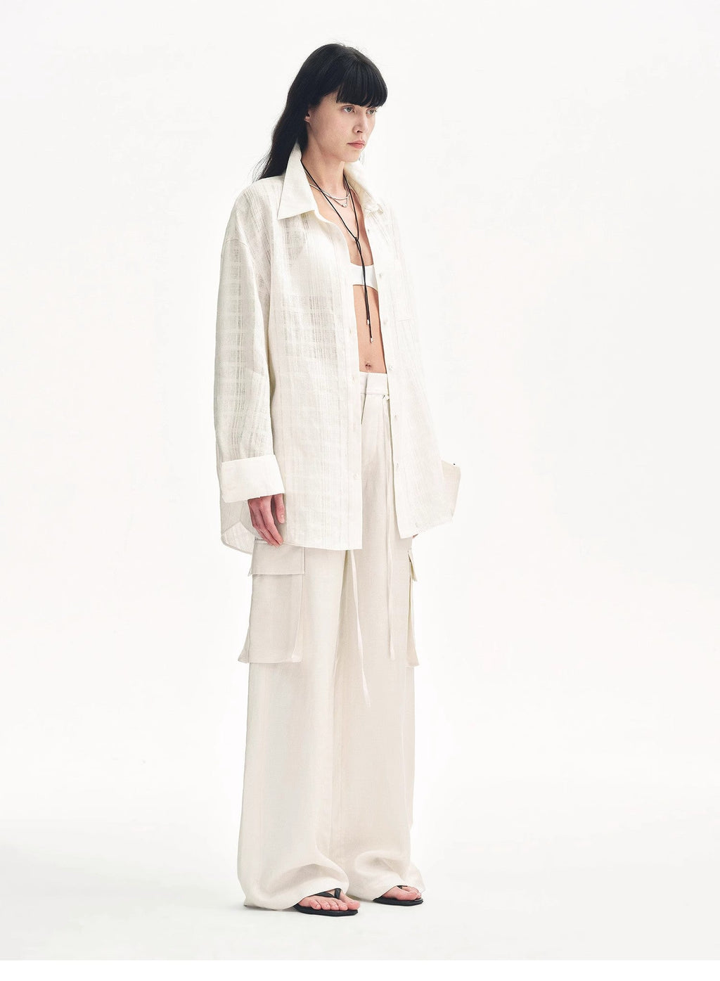 "Rhythm in the Same Frequency" white wide-leg cargo pants with an oversized white shirt, three-quarter view