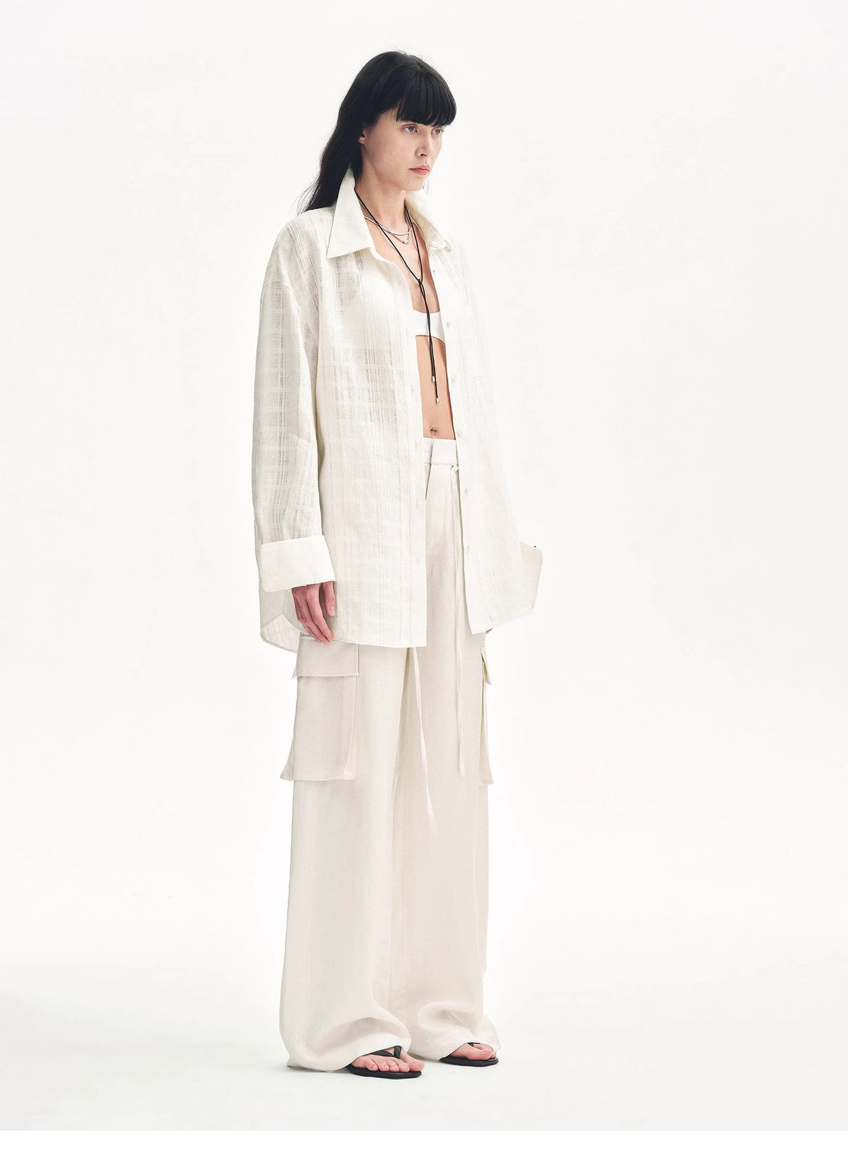 "Rhythm in the Same Frequency" white wide-leg cargo pants with an oversized white shirt, three-quarter view
