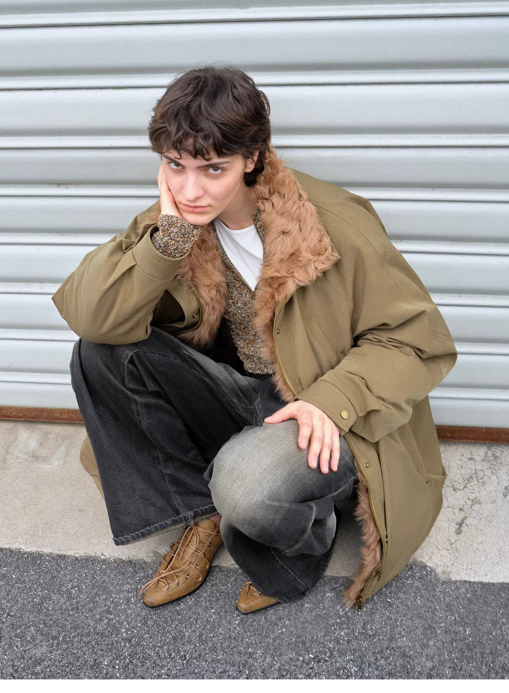 "Amber Pine Forest" olive down parka with curly collar, crouching pose with wide-leg jeans