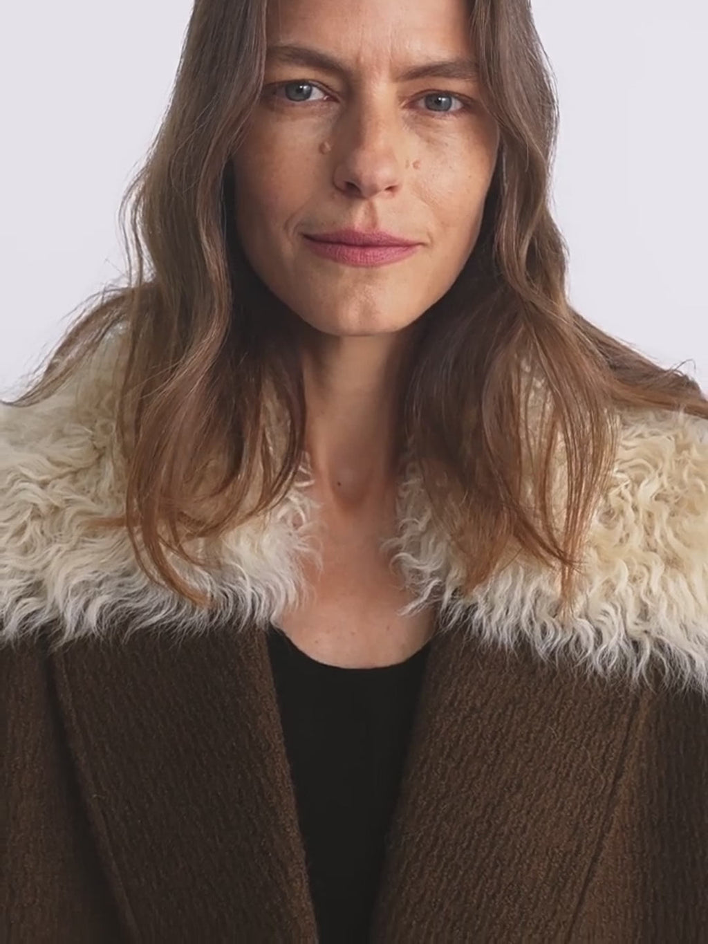 Close-up of the "Vertical Texture" wool tweed coat showing the fluffy detachable fur collar