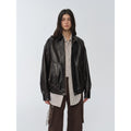 "New York Student" black waxed leather bomber jacket worn over a striped shirt — front view
