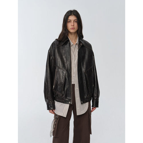 "New York Student" black waxed leather bomber jacket worn over a striped shirt — front view